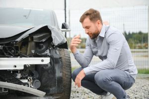 Remontas po auto įvykio - vyras prie savo automobilio | AV Terminal